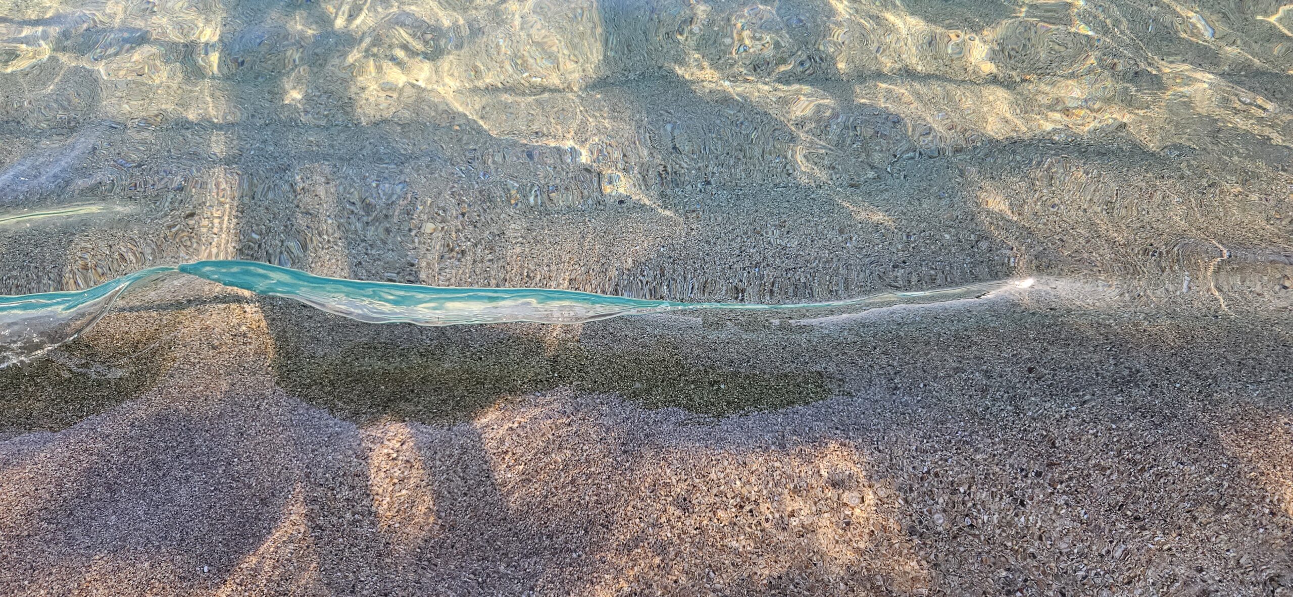 Sardinia, east coast, crystal clear seawater over fine sand with shimmering light reflections and gentle waves