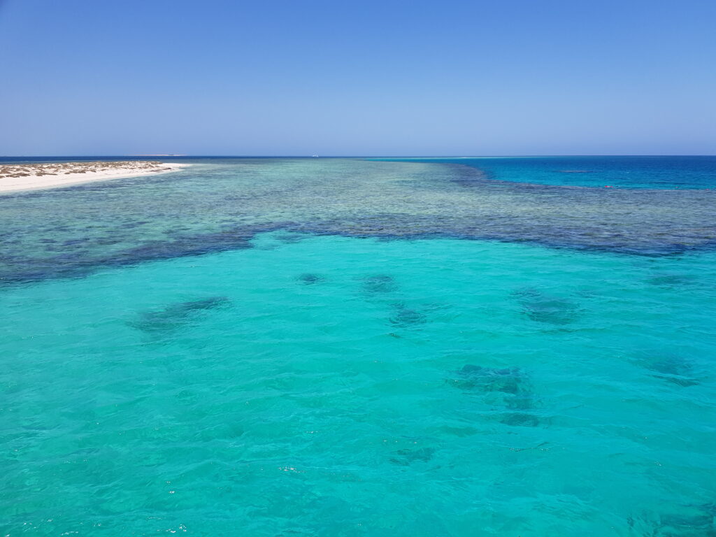 Ägypten, Marsa Alam, Rotes Meer, flaches Korallenriff bei Wadi el Gemal mit türkisblauem Wasser und hellem Sand