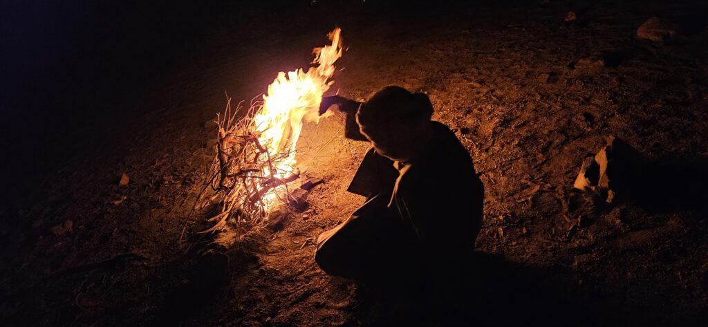 Ababda Mann am Feuer in der Wüste im Wadi el Gemal in Ägypten bei Nacht