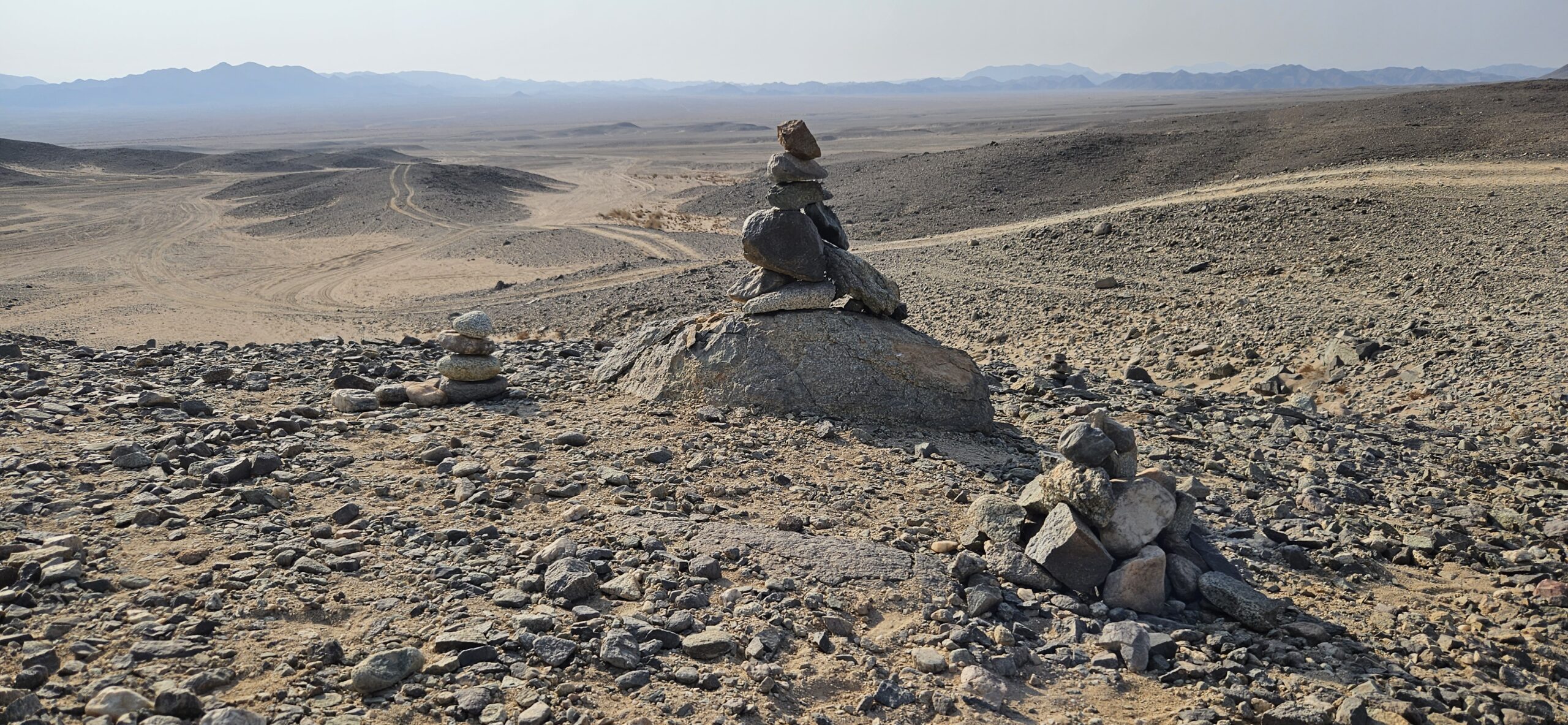 Steinmarkierungen in der Wüste im Wadi el Gemal in Ägypten mit Blick auf weite Karawanenlandschaft